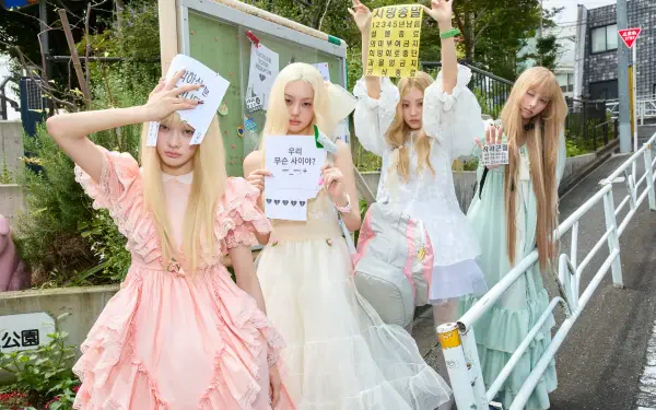 ILLIT members in pastel dresses pose outdoors with signs in this 4K Ultra HD Break Even PC desktop wallpaper and background.