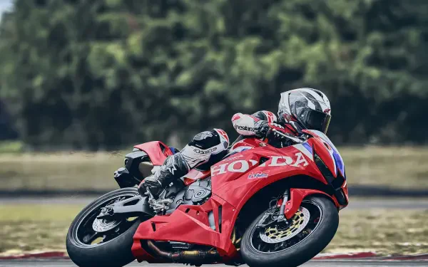 Honda CBR600RR racing motorcycle leaning through a track corner, featured in a 4K Ultra HD PC desktop wallpaper and background.