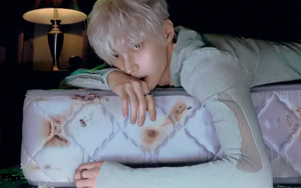 RIIZE Insomnia 4K Ultra HD desktop wallpaper of a silver-haired RIIZE member resting on a patterned pillow in bed.