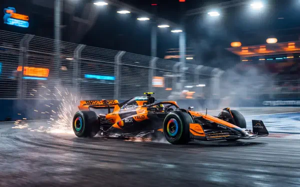 McLaren MCL40 F1 race car speeding through a night circuit, spraying sparks—5K Ultra HD desktop wallpaper and background.