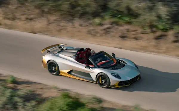 5K Ultra HD desktop wallpaper featuring an Aston Martin Valhalla Spider convertible sports car speeding along a scenic road.