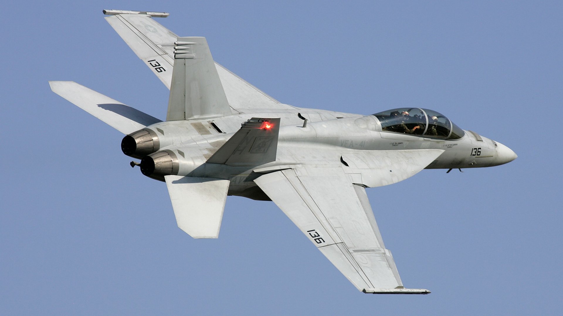 HD desktop wallpaper of a McDonnell Douglas F/A-18 Hornet military jet flying against a clear blue sky.