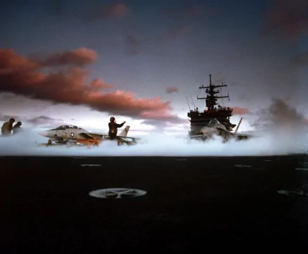 A striking HD wallpaper featuring the USS Enterprise (CVN-65) aircraft carrier, with military personnel and jet fighters on a misty flight deck against a dramatic sky.