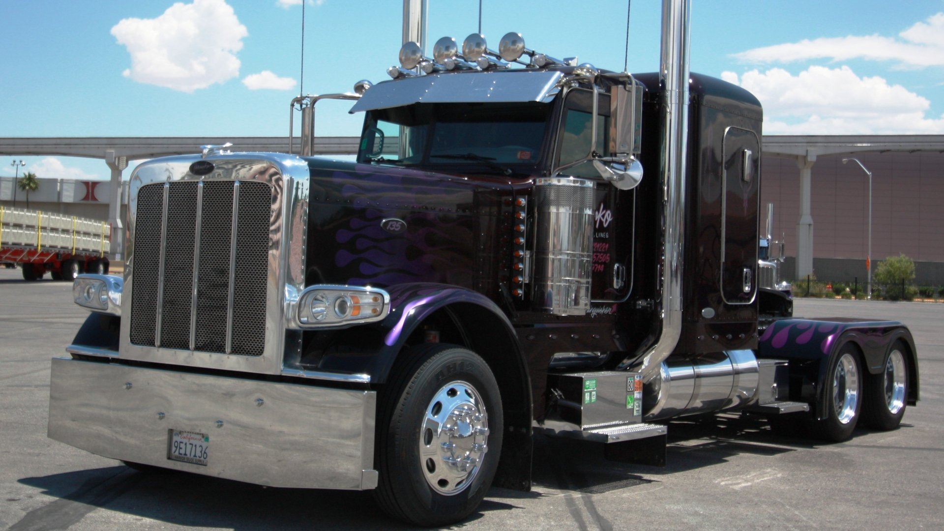 A polished, purple truck with chrome details and prominent headlights, set against a clear blue sky. This HD image serves as a striking desktop wallpaper and background.