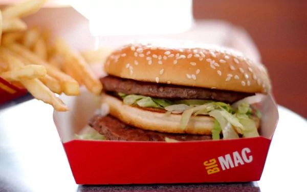 HD PC desktop wallpaper featuring a close-up of a Big Mac burger with lettuce, cheese, and two beef patties, alongside crispy French fries in a bright red container.