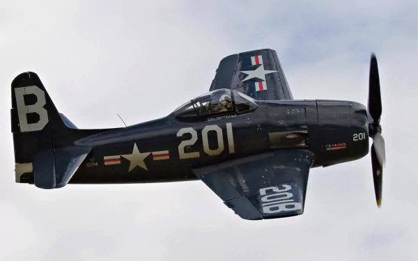HD desktop wallpaper featuring a military Grumman F8F Bearcat aircraft in flight against a cloudy sky.