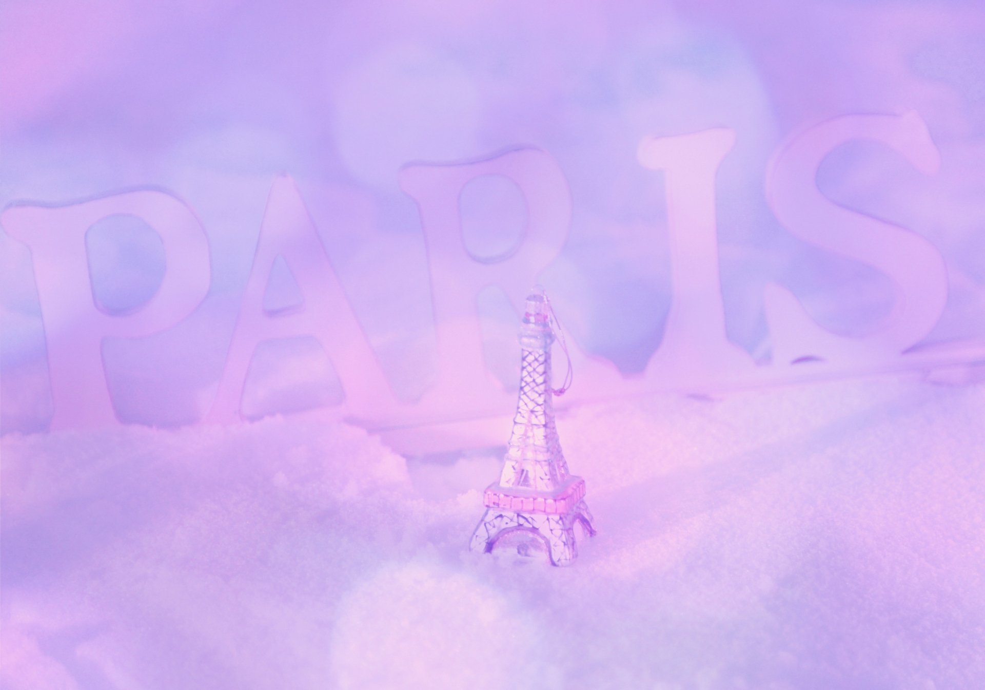4K Ultra HD desktop wallpaper featuring a delicate, man-made miniature Eiffel Tower against a soft, dreamy pastel background with faint PARIS lettering.