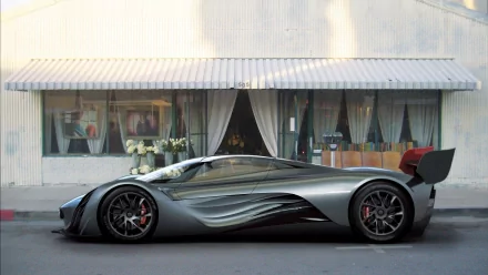 Sleek silver Mazda Furai concept vehicle side view against a storefront — high-resolution HD PC desktop wallpaper/background.