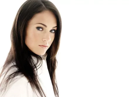 HD wallpaper featuring Megan Fox, showcasing her striking features and captivating gaze against a minimalistic white background. A stylish addition to any desktop.