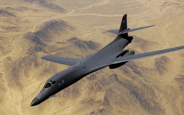 Military Rockwell B-1 Lancer bomber flying over a desert landscape, captured in high definition for a PC desktop background.