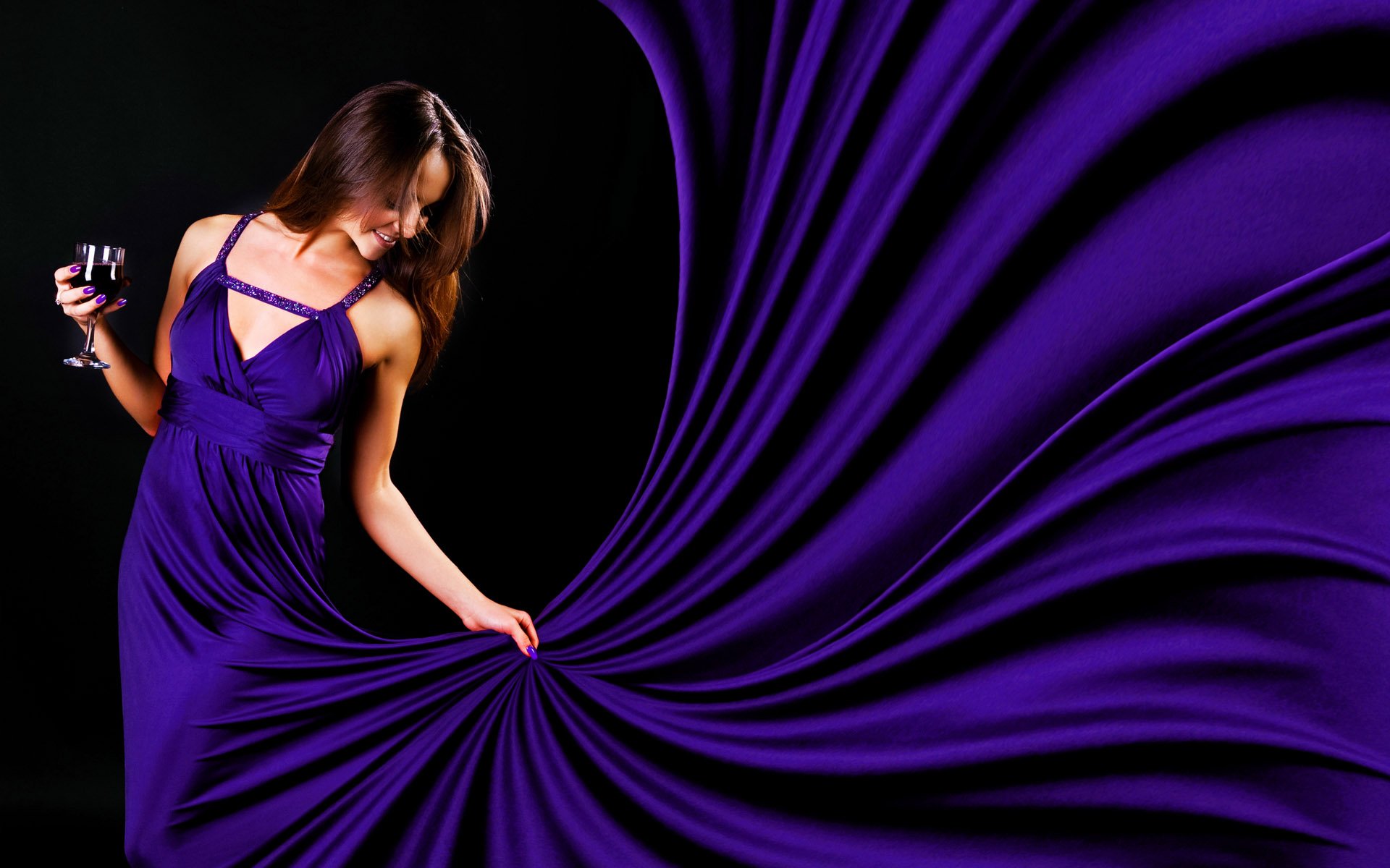 HD PC desktop wallpaper featuring a woman model in a flowing purple dress holding a glass, set against a dark background with fabric-like waves.