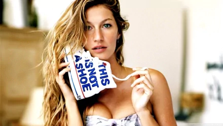 HD PC desktop wallpaper featuring celebrity Gisele Bündchen holding a mug that reads THIS IS NOT A SHOE, with a soft, bright background.