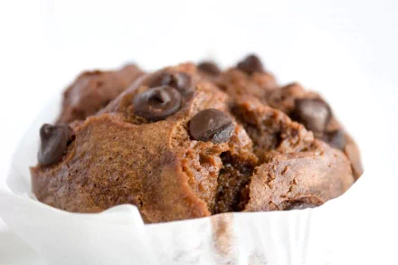 A close-up HD image of a chocolate muffin with chocolate chips, set as a desktop wallpaper and background.
