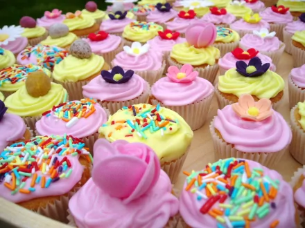 HD desktop wallpaper featuring an array of colorful cupcakes topped with various vibrant decorations.