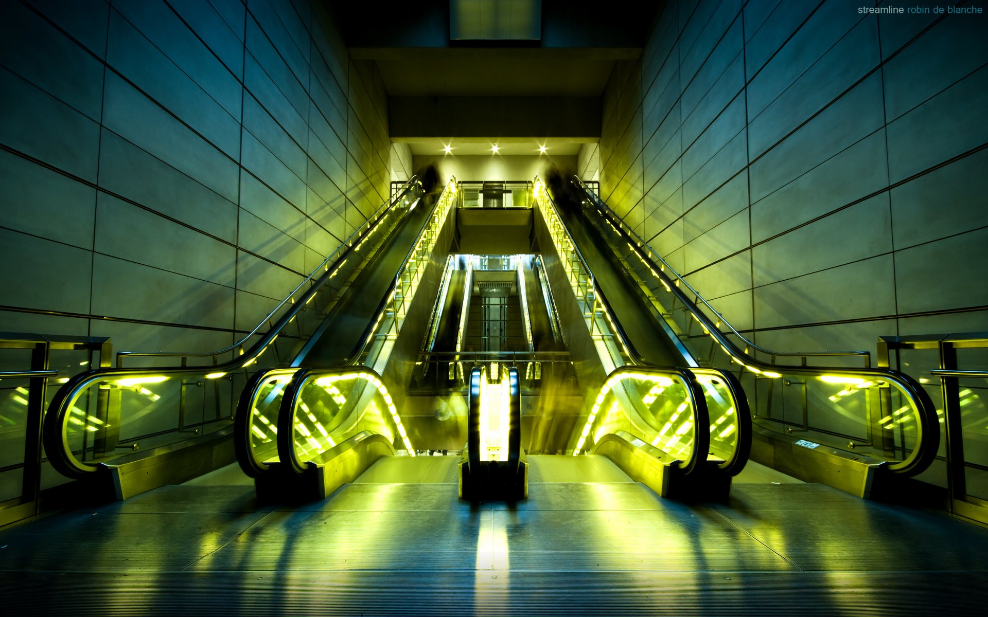HD desktop wallpaper featuring a man-made escalator glowing with yellow lights in a modern architectural setting.