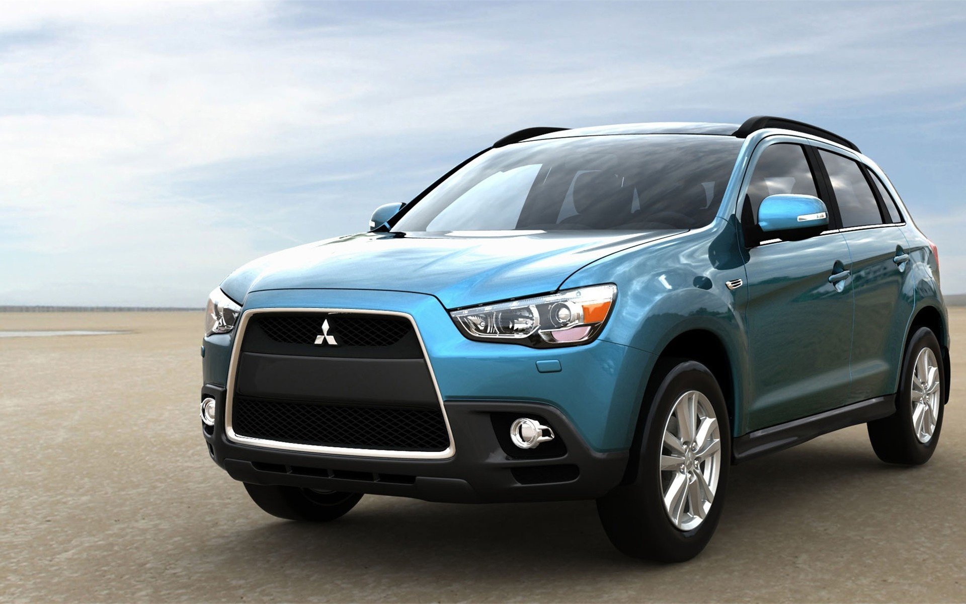 Blue Mitsubishi crossover parked on a flat coastal road, presented as an HD PC desktop wallpaper and background.