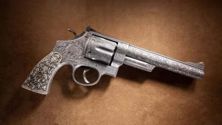 A detailed 44 Magnum revolver rests on a textured brown surface, showcasing intricate engravings that enhance its striking appearance, making it a captivating HD desktop wallpaper.