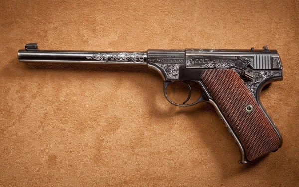 HD desktop wallpaper featuring a man-made Colt pistol with intricate engravings and a textured wooden grip on a tan background.