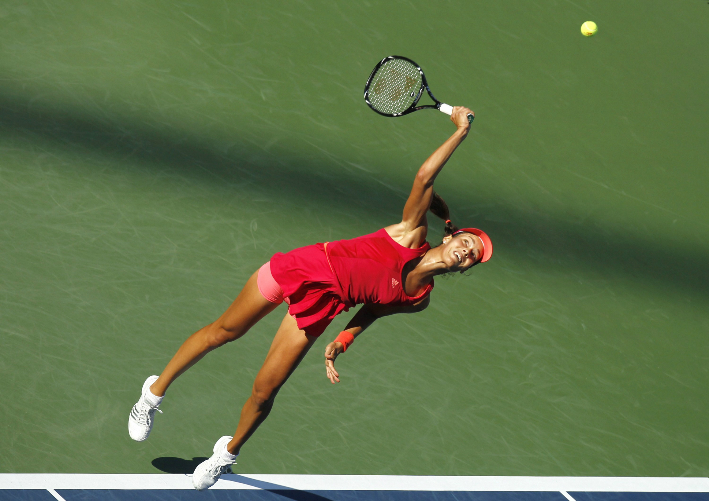 Ana Ivanovic serving a powerful shot in a sports match.