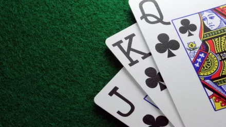 Close-up of playing cards featuring Jack, Queen, and King of spades, set against a textured green background, creating a visually striking HD desktop wallpaper.