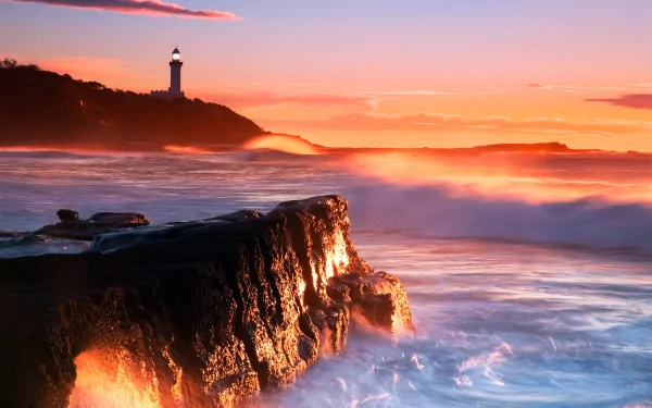 A stunning sunset illuminates the coastline, with waves crashing against rocky shores and a lighthouse standing tall against the orange sky, creating a captivating ocean scene.