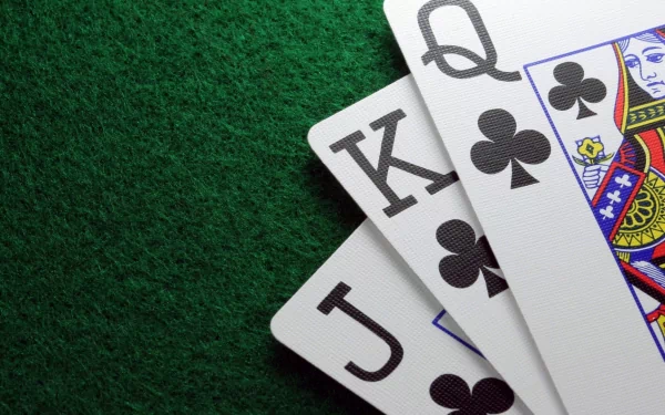 Close-up of playing cards featuring Jack, Queen, and King of spades, set against a textured green background, creating a visually striking HD desktop wallpaper.