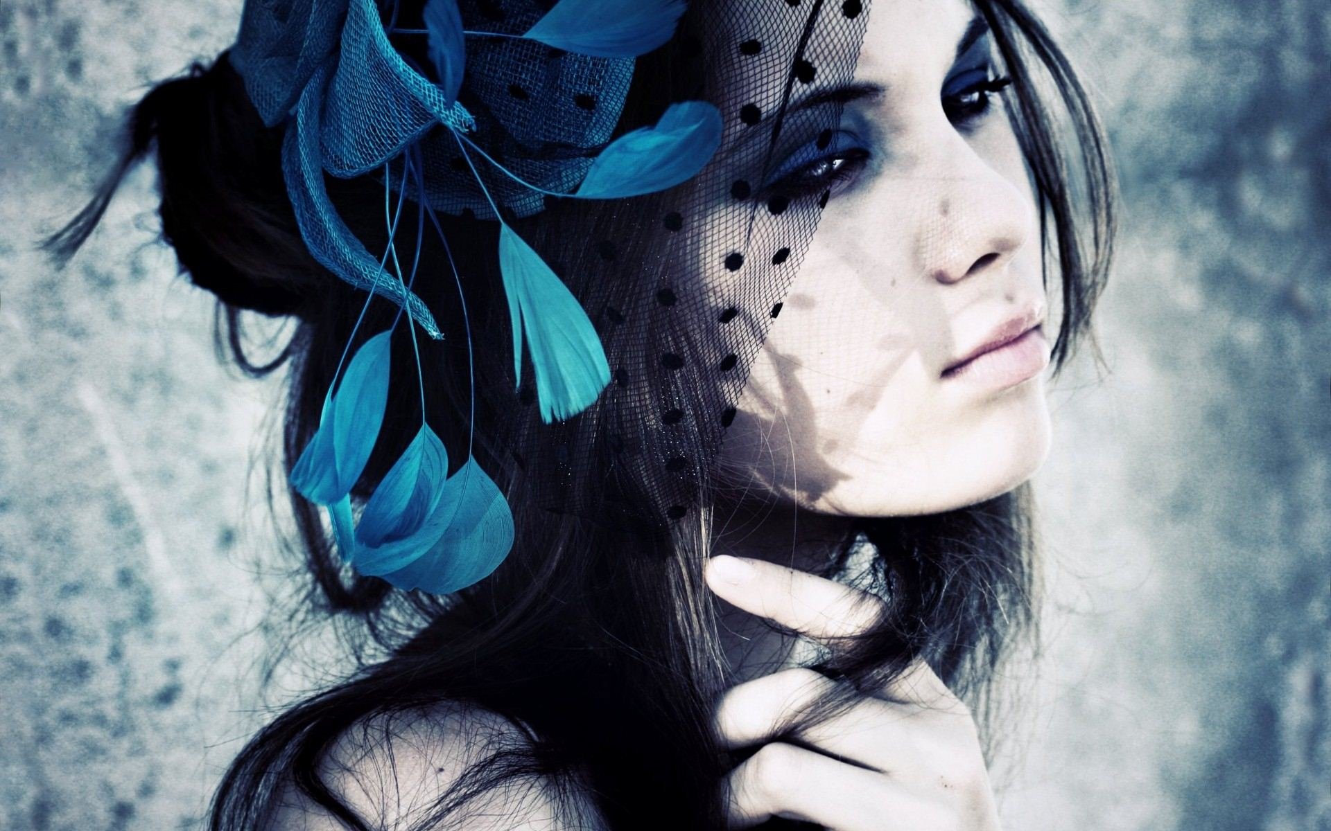 Artistic HD desktop wallpaper featuring a woman with a striking blue flower accessory, gazing thoughtfully against a textured backdrop.