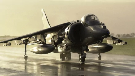 4K Ultra HD military-themed desktop wallpaper featuring a Harrier Jump Jet taxiing on a wet runway with muted, atmospheric lighting.