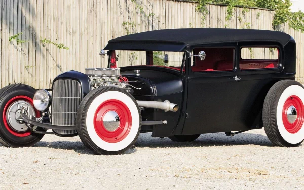 A striking black Ford hot rod with whitewall tires, showcasing classic car design, stands against a rustic wooden backdrop. This HD image makes an impressive desktop wallpaper.