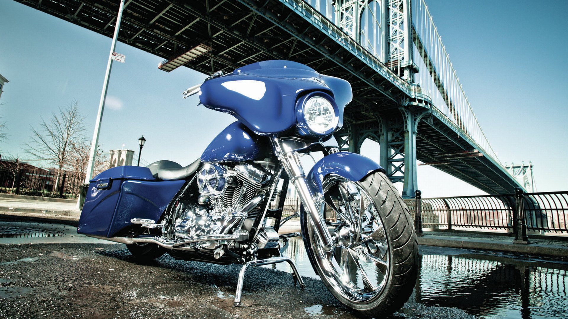 A striking blue Harley-Davidson motorcycle is showcased in this 4K Ultra HD wallpaper, set against the backdrop of an impressive bridge. Bright chrome detailing adds to its allure.