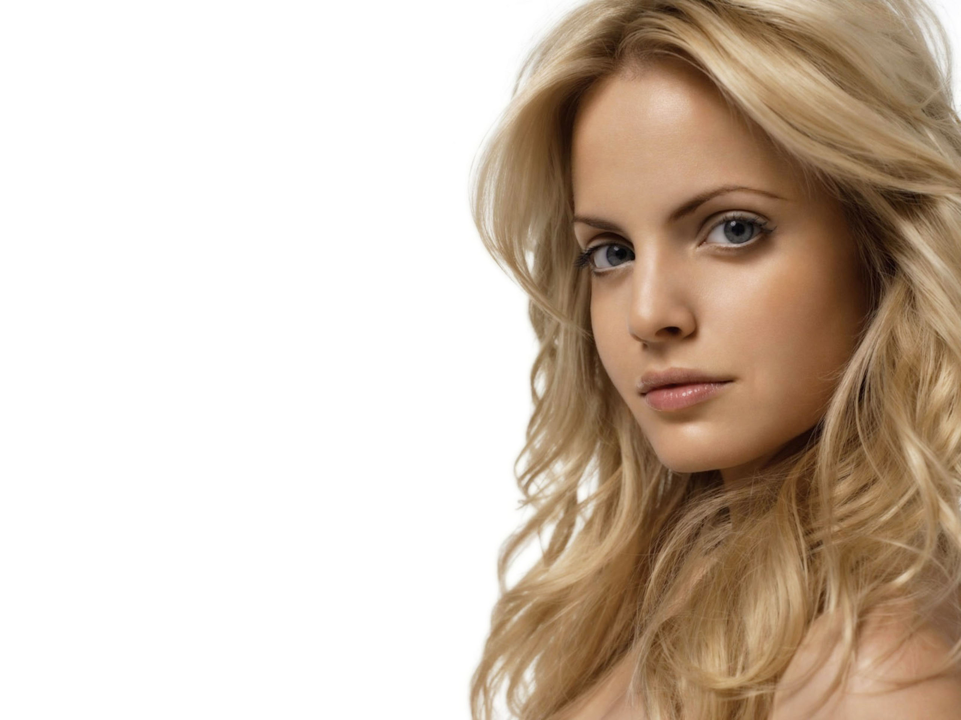 Mena Suvari, blonde celebrity with striking blue eyes, posing for a captivating desktop wallpaper.