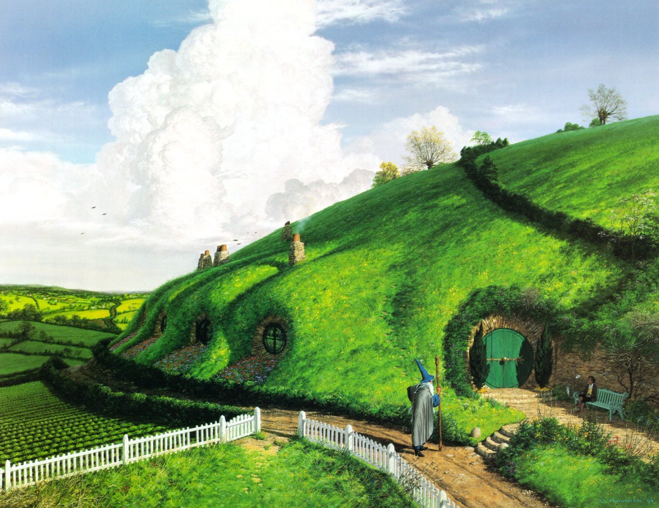 HD fantasy wallpaper of The Lord of the Rings’ Comarca, showcasing lush green hills with hobbit holes and a character standing near a round green door.
