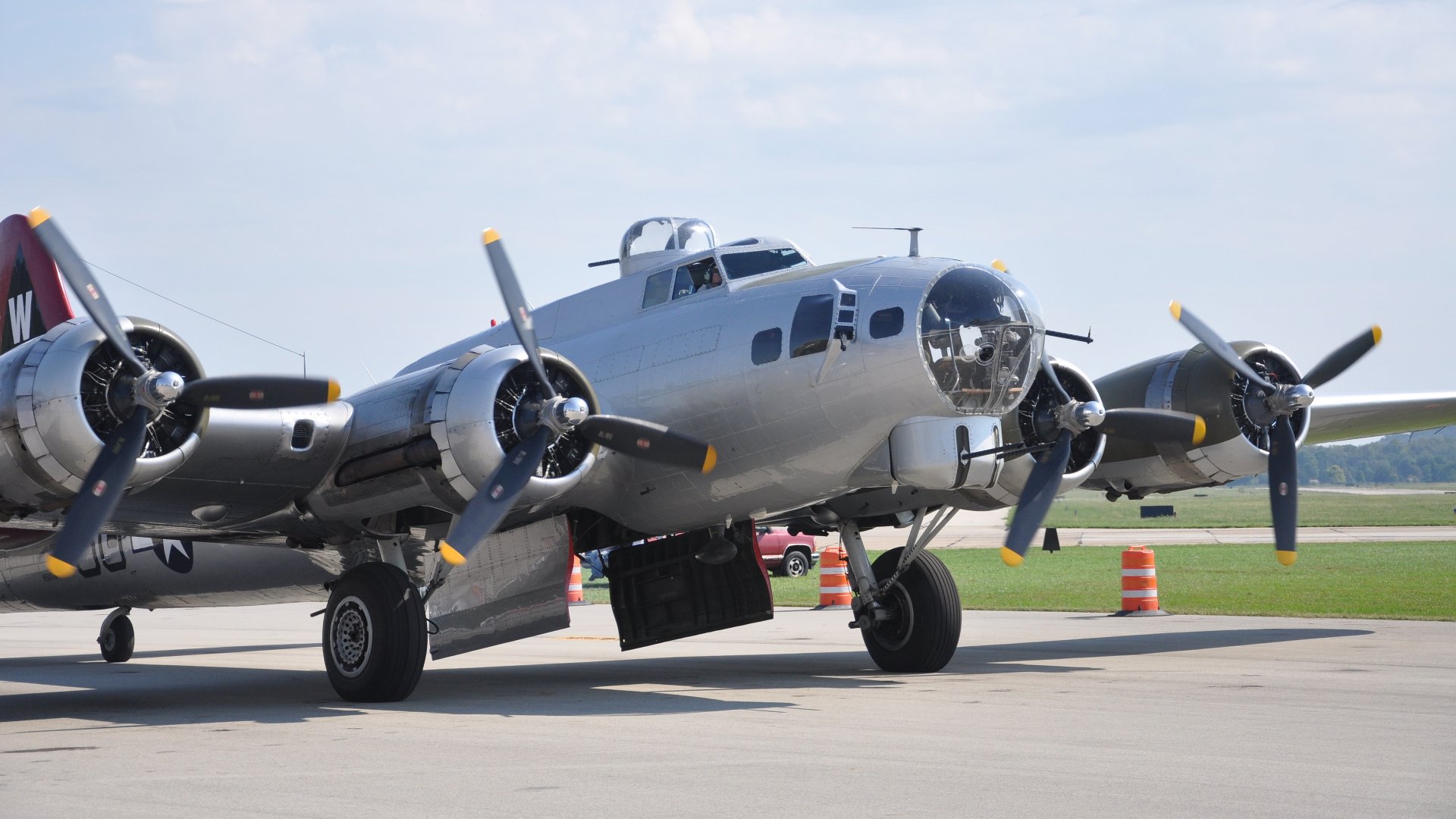 Boeing B-17 Flying Fortress military bomber on a sunny tarmac, close-up of nose and propellers; 4K Ultra HD PC desktop wallpaper and background.