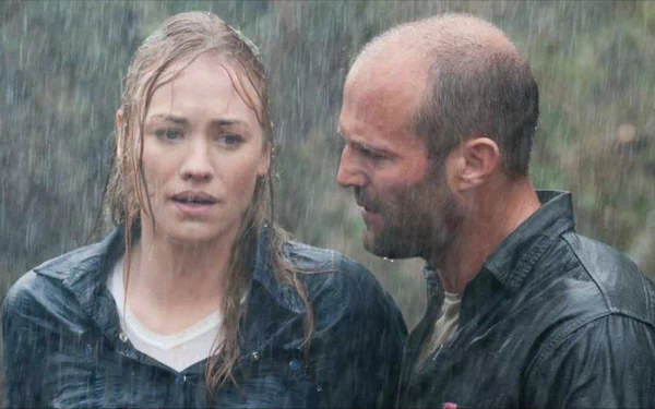 HD desktop wallpaper from the movie Killer Elite, depicting two characters in a rain-soaked, intense moment.