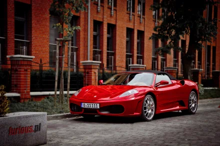 A red Ferrari F430 sports car parked on a cobblestone street in front of a brick building, showcased as an HD PC desktop wallpaper and background.
