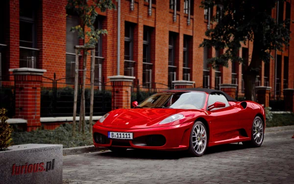 A red Ferrari F430 sports car parked on a cobblestone street in front of a brick building, showcased as an HD PC desktop wallpaper and background.
