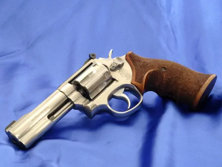 Man-made Smith & Wesson revolver with wooden grip resting on blue cloth — HD PC desktop wallpaper/background.