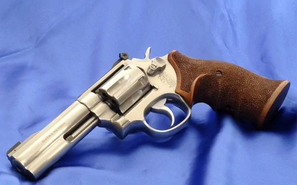 Man-made Smith & Wesson revolver with wooden grip resting on blue cloth — HD PC desktop wallpaper/background.