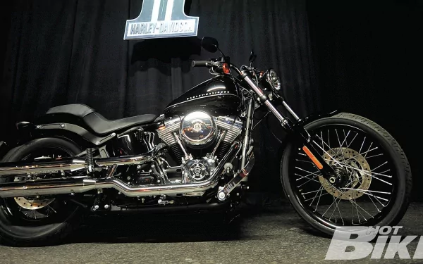 Black Harley-Davidson motorcycle vehicle on a dark stage, chrome engine and spoked front wheel — HD PC desktop wallpaper and background.