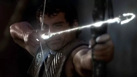 HD PC desktop wallpaper from the movie Immortals: a warrior draws a bow, aiming a glowing, lightning-charged arrow against a dark, dramatic background.