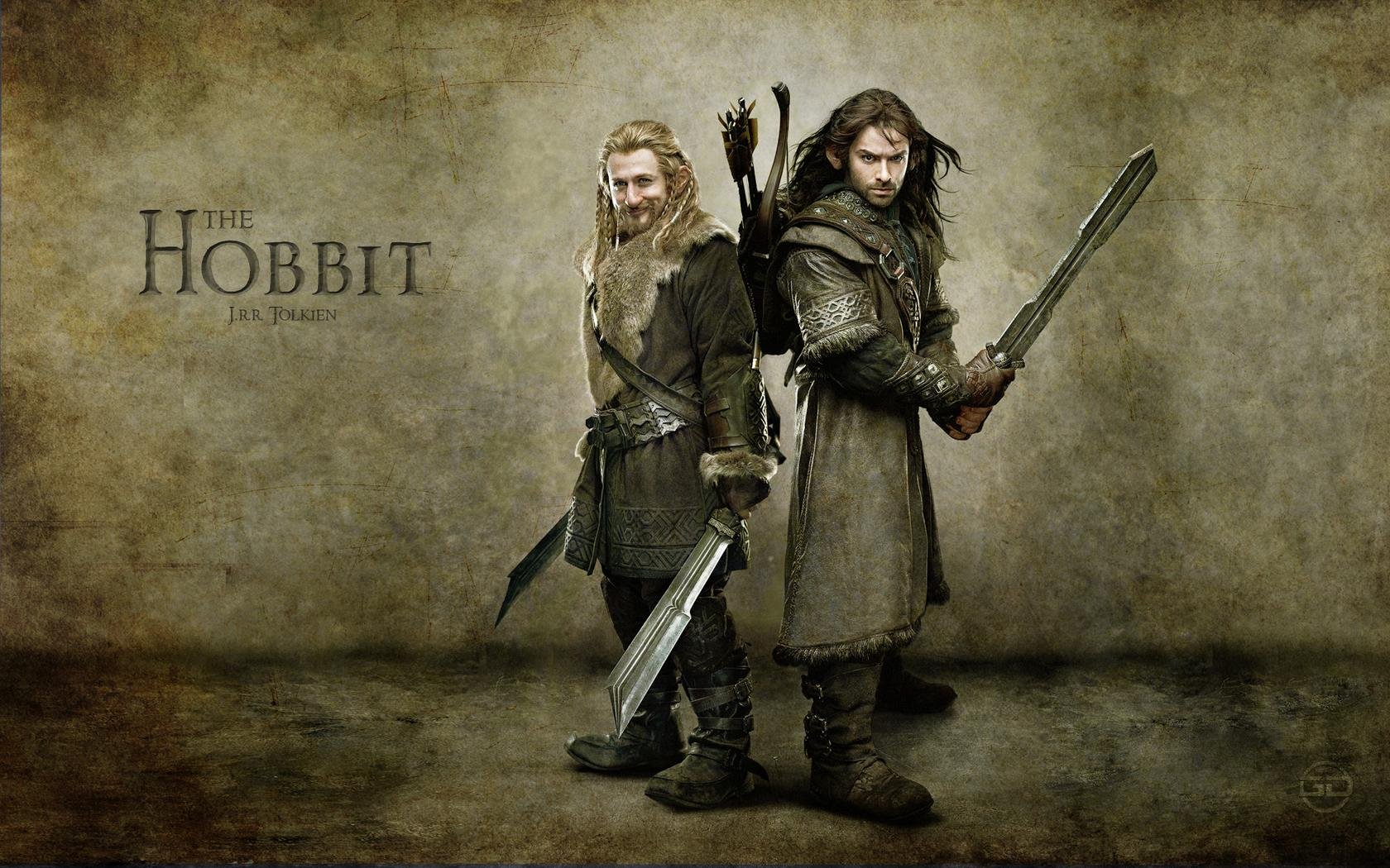 HD PC desktop wallpaper from the movie The Hobbit: An Unexpected Journey: two rugged warriors stand back-to-back with swords against a weathered parchment background, film title logo at left.