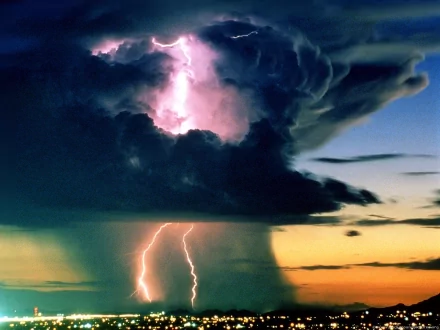 A striking HD wallpaper depicting a dramatic lightning storm, showcasing vibrant bolts cutting through dark clouds against a colorful sunset backdrop.