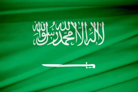 A vibrant 4K Ultra HD wallpaper featuring the flag of Saudi Arabia, showcasing its green background and white Arabic script along with a traditional sword design.