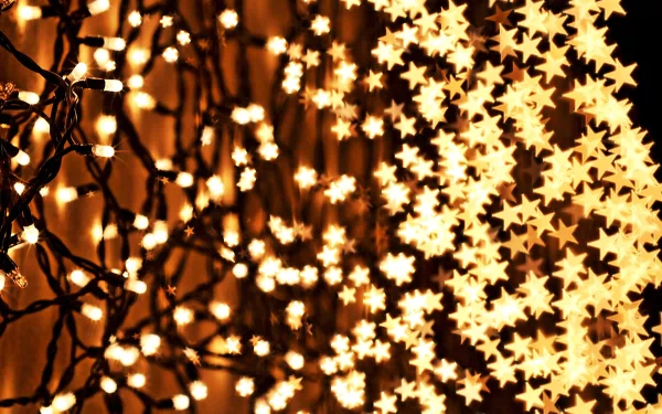 A close-up of twinkling Christmas lights, featuring star-shaped decorations, creating a festive holiday atmosphere. This high-definition image makes a vibrant desktop wallpaper or background.