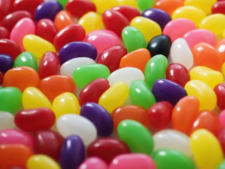 A vibrant assortment of colorful jelly beans scattered across the surface, creating a delightful candy-themed HD desktop wallpaper.