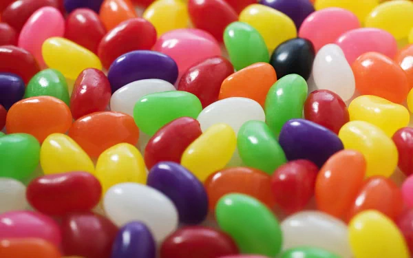 A vibrant assortment of colorful jelly beans scattered across the surface, creating a delightful candy-themed HD desktop wallpaper.