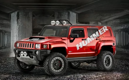 HD PC desktop wallpaper/background of a red Hummer vehicle in a dim concrete garage, showing rugged off-road tires, roof lights and a bold Hummer logo.