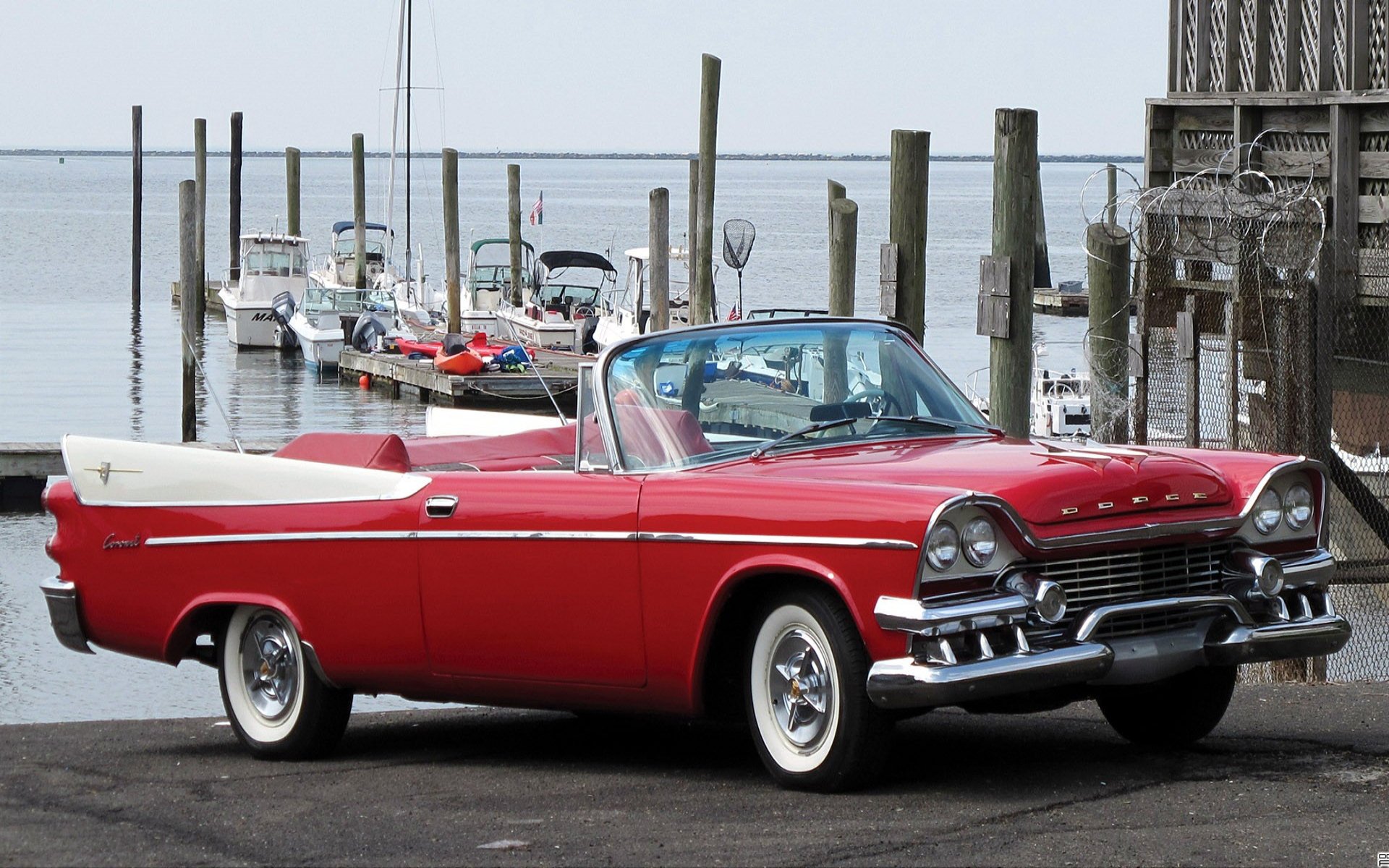 A classic red Dodge convertible parked near a marina with boats in the background, captured in high definition for a PC desktop wallpaper.