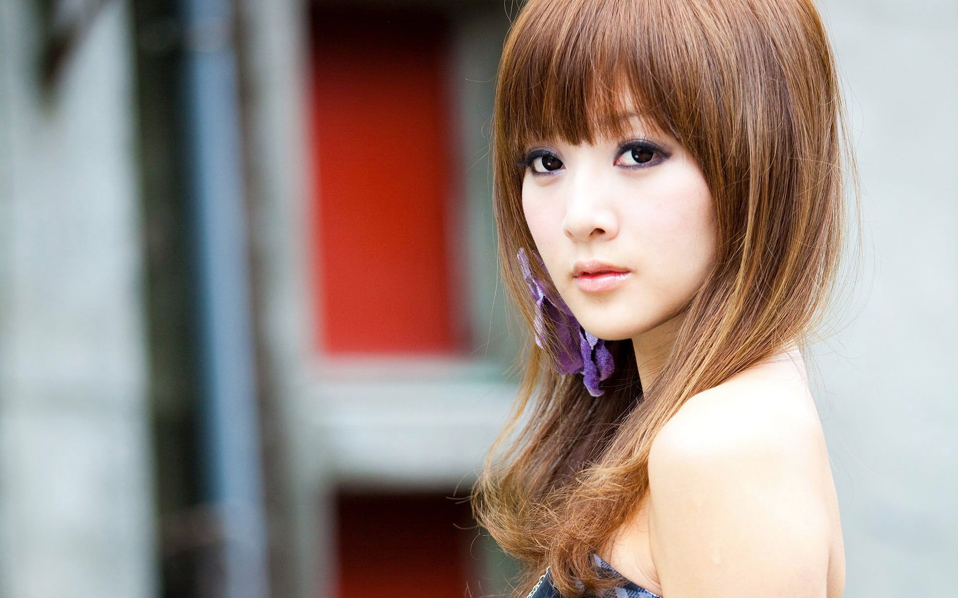 HD desktop wallpaper of an oriental Asian woman named Mikako Zhang Kaijie, featuring her with light brown hair and a serious expression against a blurred background.