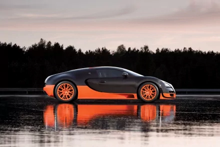 A sleek Bugatti sits against a serene backdrop, showcasing its striking design with a glossy black and orange finish, reflecting beautifully on the water's surface in this HD desktop wallpaper.